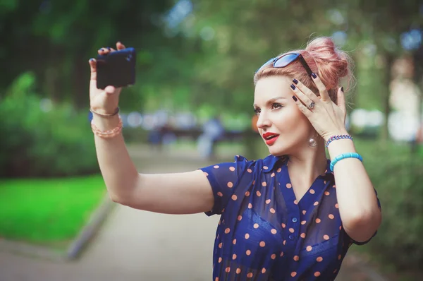 Beautiful young woman in fifties style taking picture of herself — Stock Photo, Image