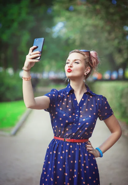 Hermosa mujer joven en el estilo de los años cincuenta tomando fotos de sí misma —  Fotos de Stock