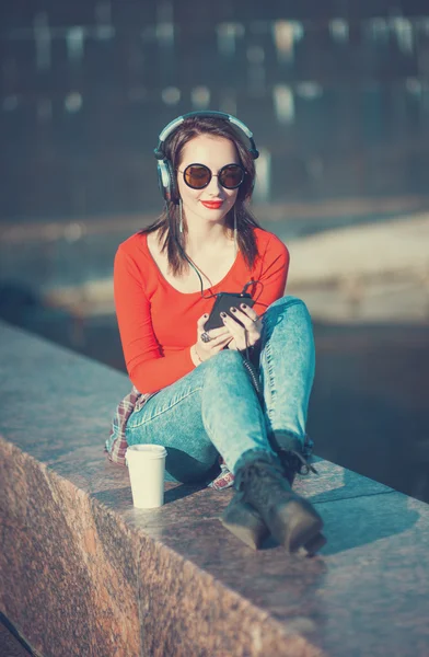 Mooie hipster meisje in zonnebril muziek luisteren — Stockfoto