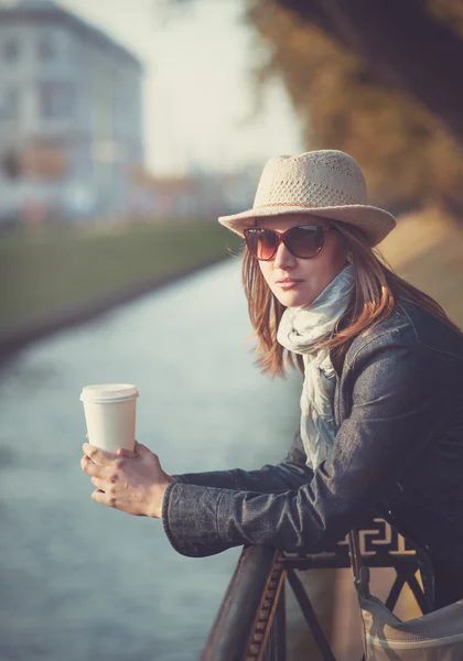 Красивая женщина в шляпе и шарфе с чашкой кофе — стоковое фото