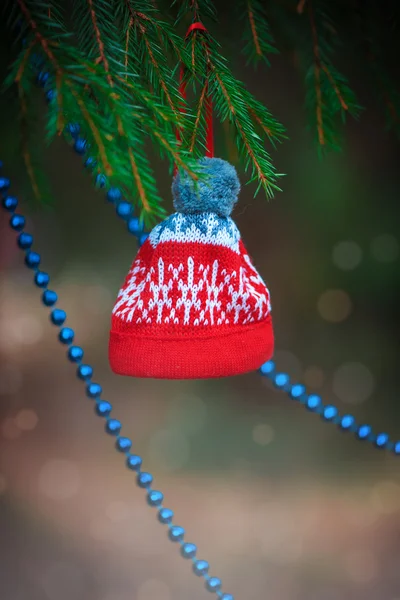 Cuentas decorativas de Navidad y sombrero en la rama de abeto —  Fotos de Stock