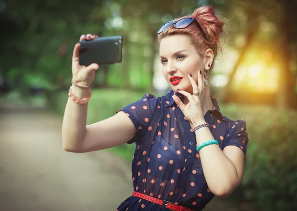 Mulher bonita em estilo dos anos cinquenta tirar foto de si mesma — Fotografia de Stock