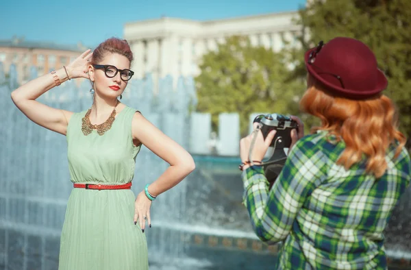 Two beautiful hipster girls taking pictures on an old camera — Stock Photo, Image