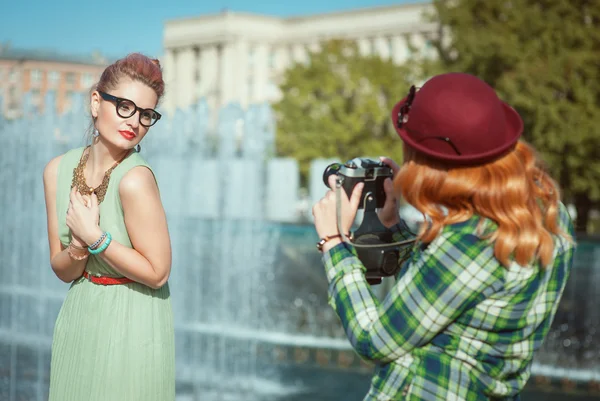 Zwei schöne Hipstermädchen, die Fotos mit einer alten Kamera machen — Stockfoto