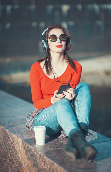 Mooie hipster meisje in zonnebril muziek luisteren — Stockfoto
