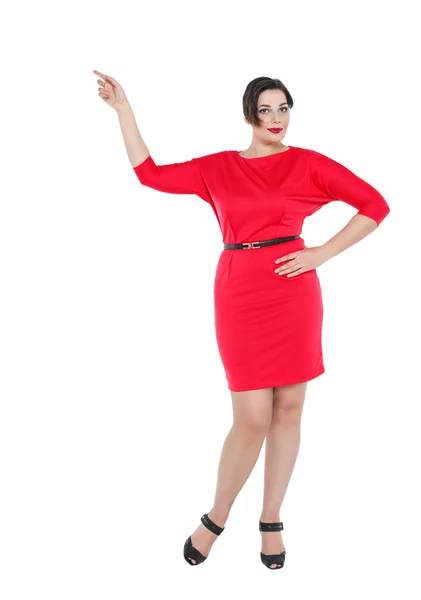 Beautiful plus size woman in red dress showing on something — Stock Photo, Image