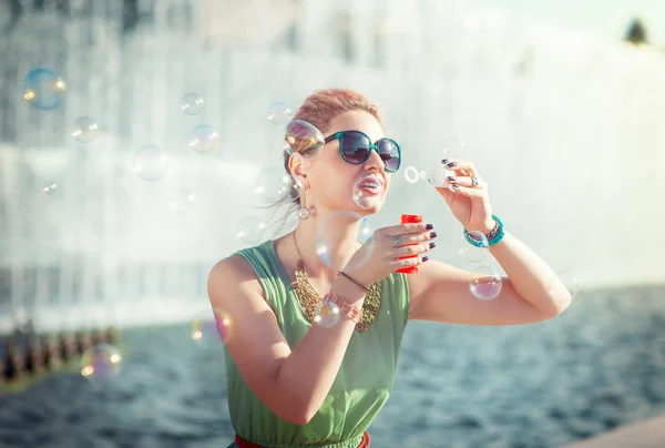 Красивая молодая девушка в винтажной одежде надувает пузыри — стоковое фото