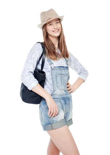 Молодая девушка моды в джинсах и шляпе позирует изолированно — стоковое фото