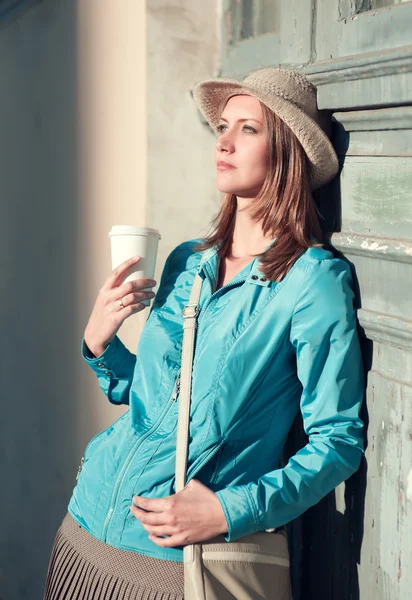 Belle jeune femme hipster en chapeau avec tasse de café en plein air — Photo