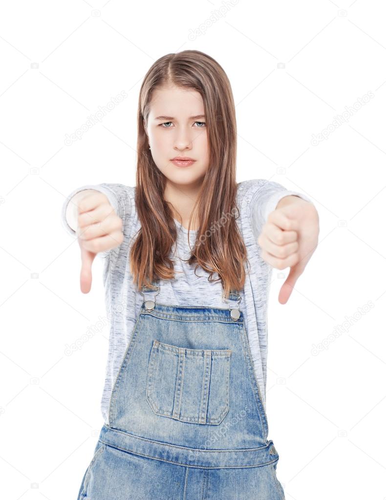 Young teenage girl with thumbs down gesture isolated 