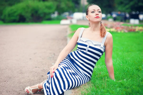 Jeune belle femme à la mode portant une robe rayée — Photo