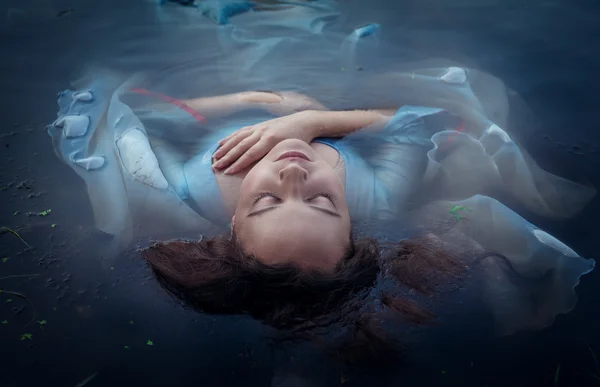 Young beautiful drowned woman in blue dress lying in the water — Stock Photo, Image