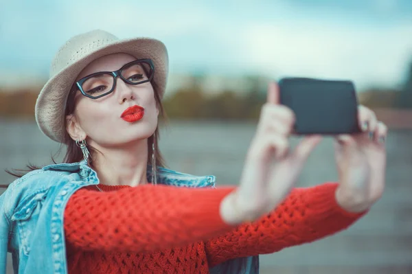 Beautiful young girl in the hat taking picture of herself, selfi — Stock Photo, Image