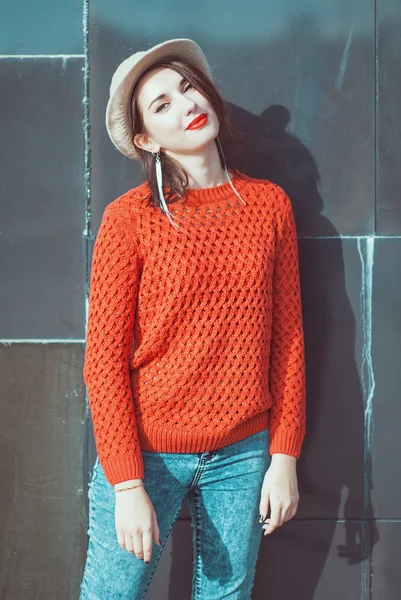 Joven hermosa chica en jersey rojo y sombrero cerca de la pared — Foto de Stock