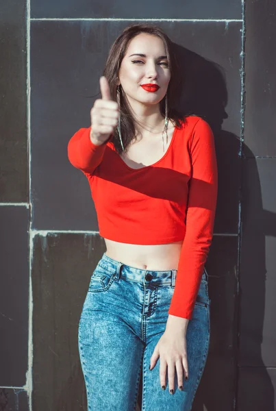 Giovane bella ragazza in camicetta rossa mostrando pollici in su — Foto Stock