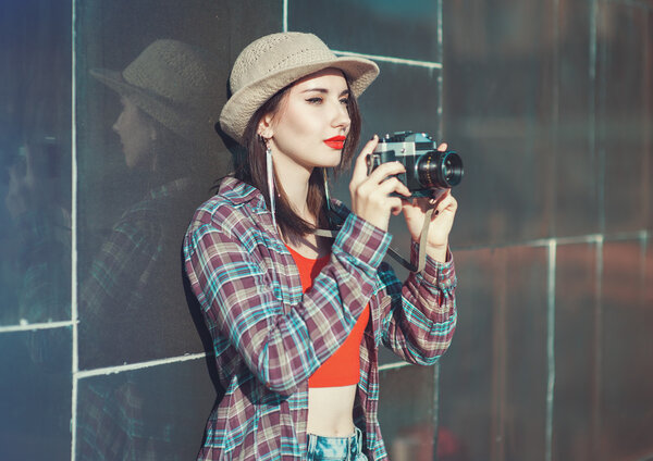 Young beautiful hipster girl with retro camera 