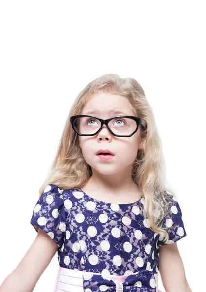 Beautiful little girl in glasses surprised looking up on somethi Stock Photo