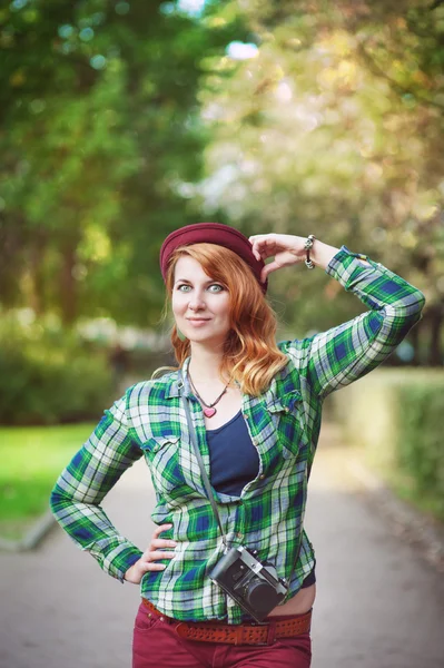 Cheerful hipster redhead girl in hat with retro camera — Stock Photo, Image