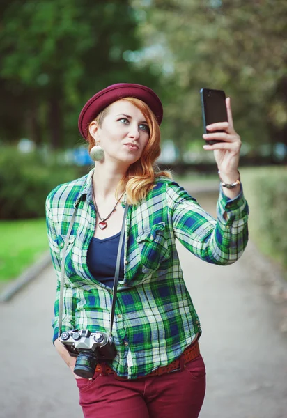 Hipster redhead woman in hat taking picture of herself — Stock Photo, Image