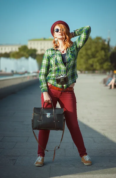 Bederní zrzka žena v klobouku a sluneční brýle s retro fotoaparát — Stock fotografie