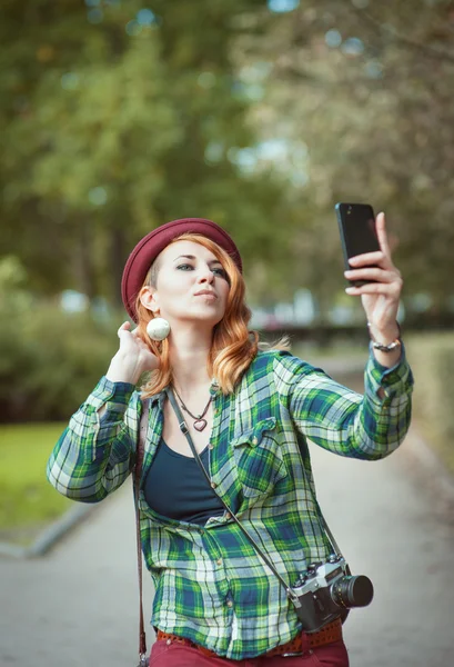 Hipster redhead woman in hat taking picture of herself — Stock Photo, Image