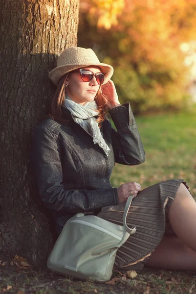 Schöne junge Frau mit Hut und Schal genießt Sonnenlicht — Stockfoto