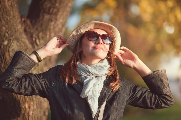 Hermosa mujer joven en sombrero y bufanda disfrutar de la luz del sol — Foto de Stock