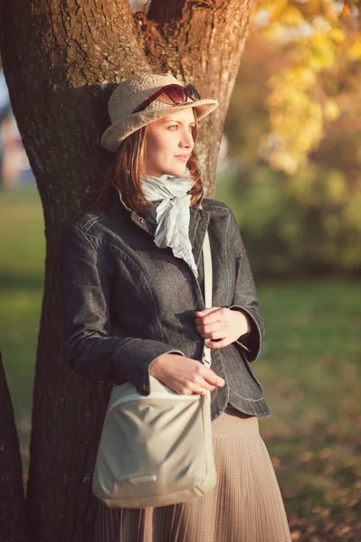 Hermosa mujer joven en sombrero y bufanda disfrutar de la luz del sol — Foto de Stock