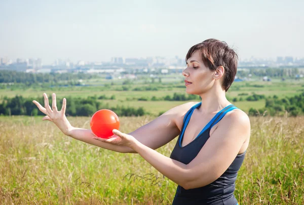 Vackra plus size kvinna tränar med liten boll — Stockfoto