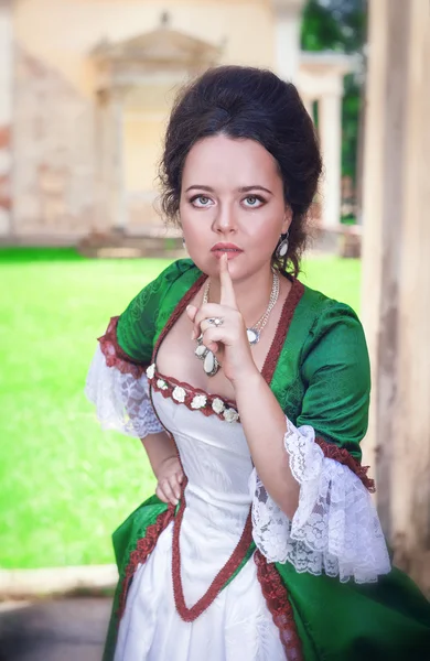 Belle femme en robe médiévale verte faisant un geste de silence — Photo