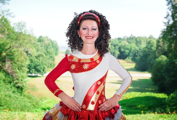 Νεαρή γυναίκα σε κόκκινο και λευκό ιρλανδικό χορό φόρεμα και ποζάρουν περούκα — Φωτογραφία Αρχείου