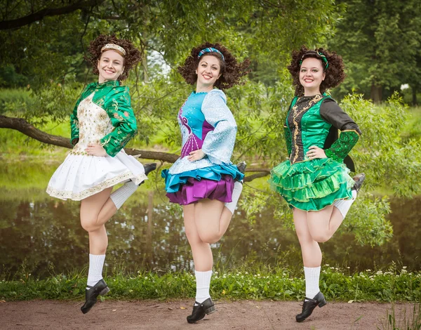 Three young beautiful girls in irish dance dress and wig dancing