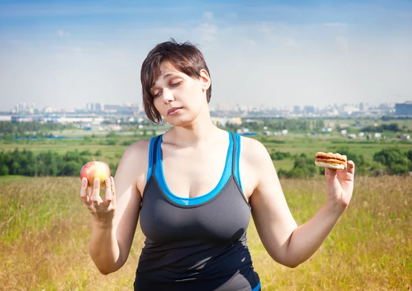 Fitness plus size woman making choice between healthy and junk f — Stock Photo, Image