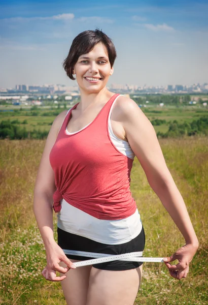 Fitness mulher bonita plus size com fita métrica — Fotografia de Stock