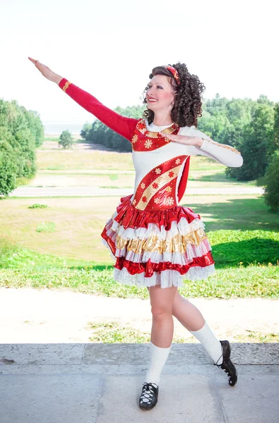 Jovem mulher em vermelho e branco irlandês vestido de dança e peruca posando — Fotografia de Stock