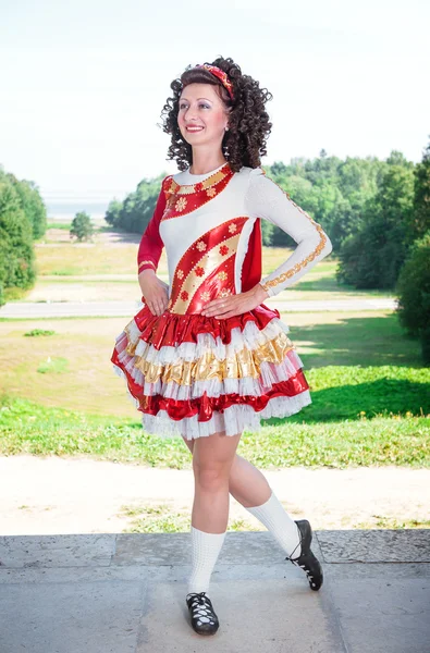 Jovem mulher em vermelho e branco irlandês vestido de dança e peruca posando — Fotografia de Stock