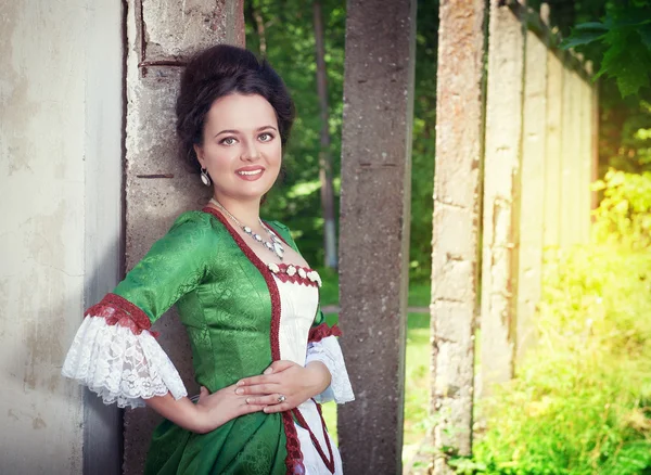 Beautiful young woman in green medieval dress — Stock Photo, Image