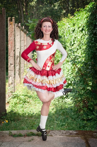 Jonge vrouw in Ierse dans jurk en pruik dansen — Stockfoto