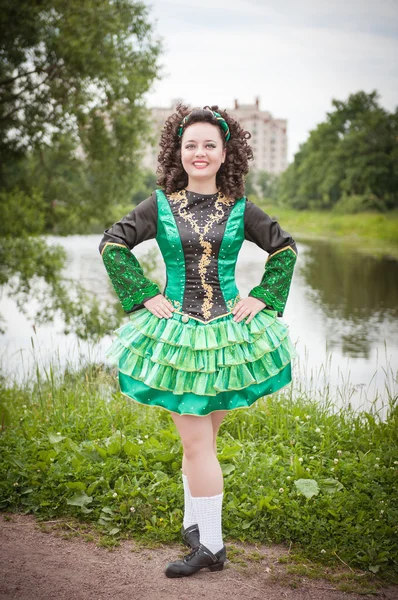 Joven chica hermosa en vestido de danza irlandesa y posando peluca — Foto de Stock