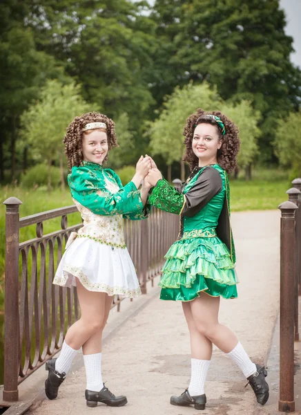 Två unga vackra flicka i irländsk dans klänning poserar utomhus — Stockfoto
