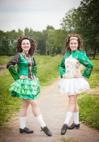 Två unga vackra flicka i irländsk dans klänning poserar utomhus — Stockfoto