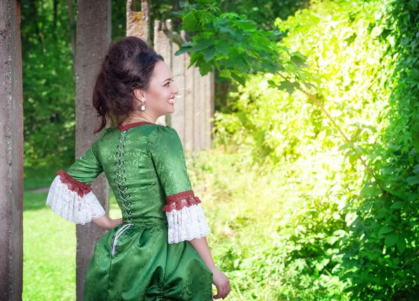 Beautiful young woman in green medieval dress — Stock Photo, Image