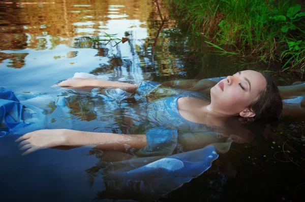 Jovem bela mulher afogada deitada na água — Fotografia de Stock