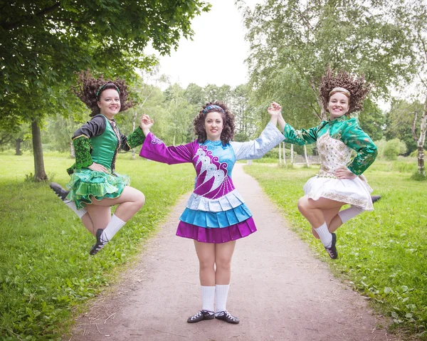 Tres chicas hermosas jóvenes en vestido de danza irlandesa posando al aire libre —  Fotos de Stock