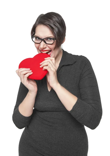 Beautiful plus size woman bites red heart isolated — Stock Photo, Image