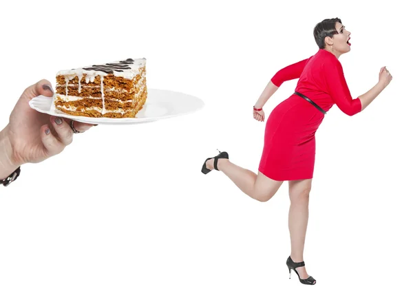 Beautiful plus size woman run away from cake isolated — Stock Photo, Image