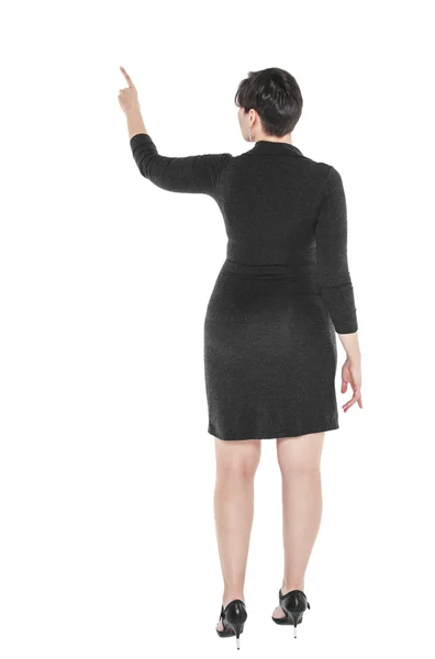 Plus size woman showing on something by finger. Back pose — Stock Photo, Image