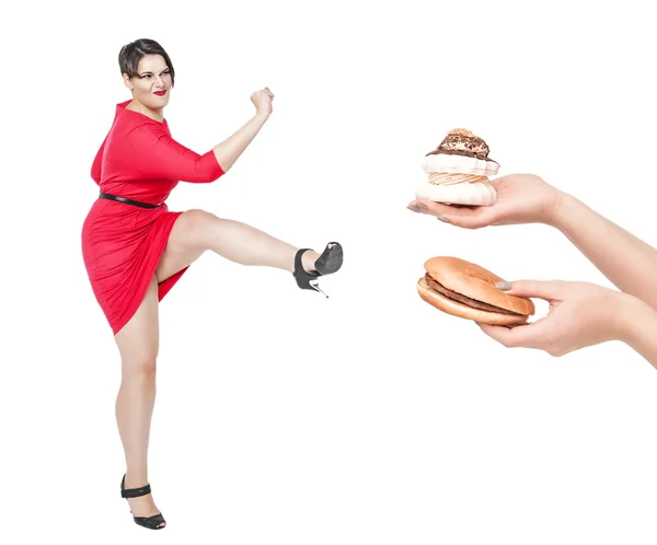 Beautiful plus size woman fighting off unhealthy food isolated — Stock Photo, Image