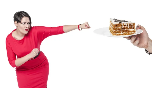 Beautiful plus size woman in red dress beating cake — Stockfoto