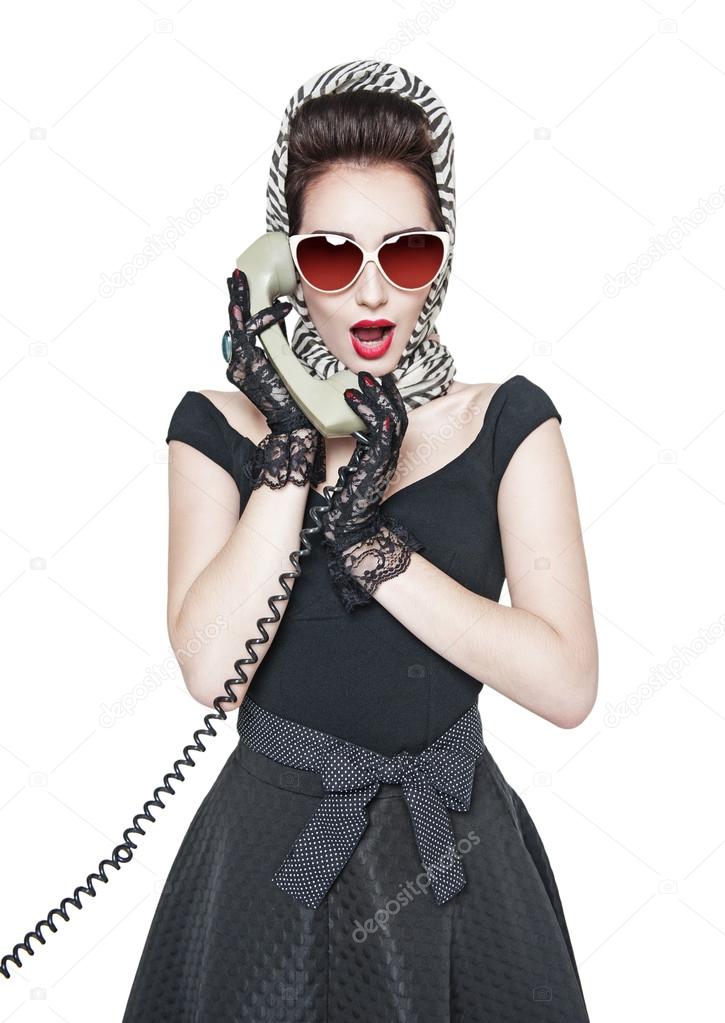 Surprised beautiful woman in pin-up style with retro telephone 